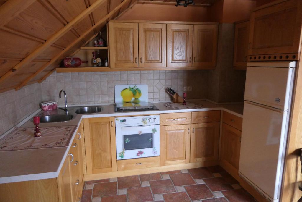 uma cozinha com armários de madeira e um frigorífico branco em Apartments and rooms Brunko em Bled