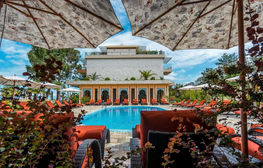 uma piscina num resort com cadeiras e guarda-sóis em Luxury Oasis Apartment em Chakvi