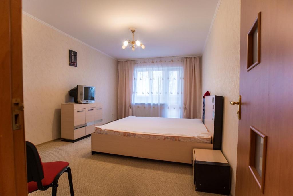 a bedroom with a bed and a tv and a window at Квартира in Kamianske