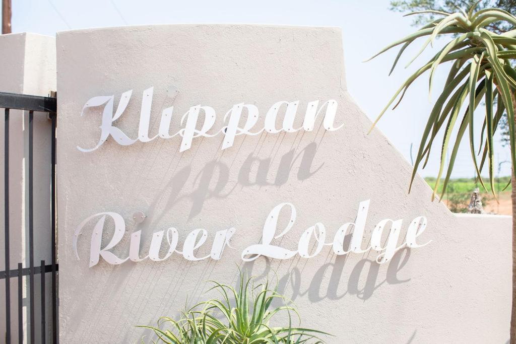 a sign for a river lodge motel on a wall at Klippan River Lodge in Groblersbrug