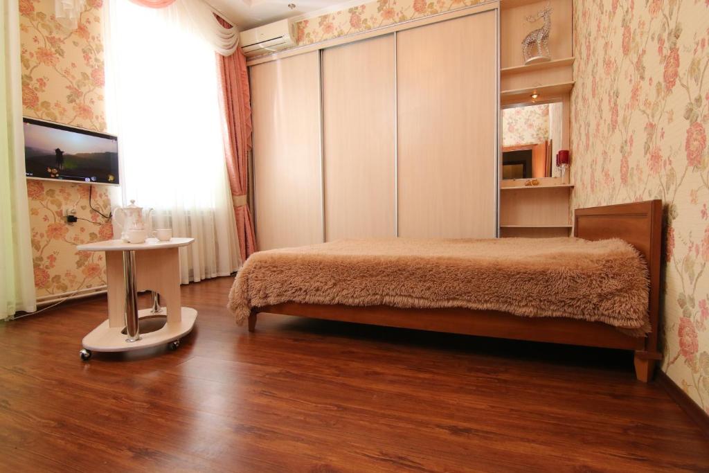 a bedroom with a bed and a window and a table at Апартаменты возле Вокзала, Центр in Dnipro