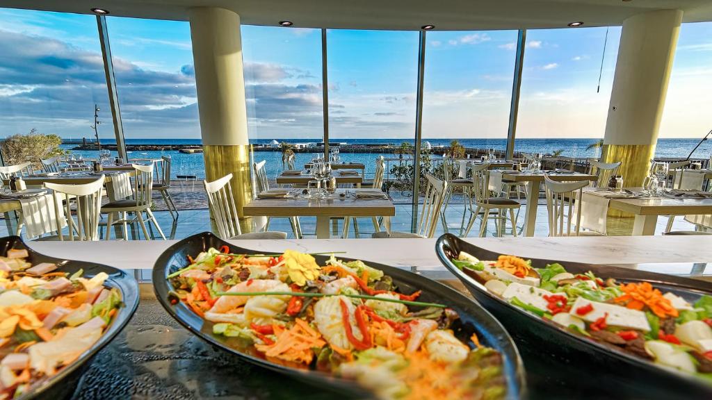 two dishes of food on a table in a restaurant at Arrecife Gran Hotel & Spa in Arrecife