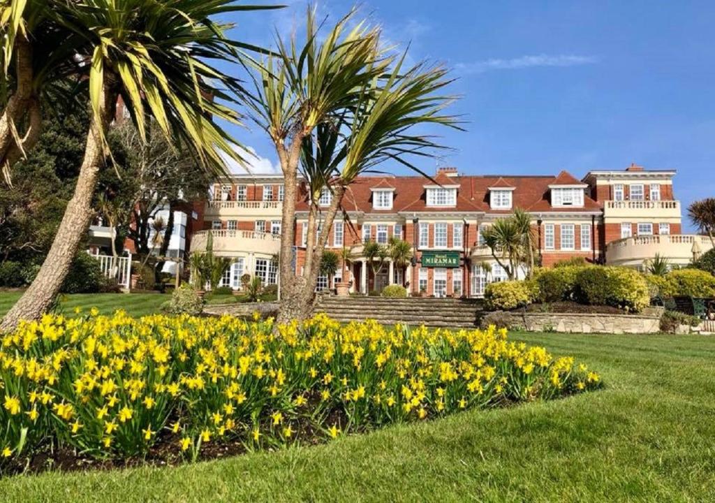 a large house with yellow flowers in the grass at Hotel Miramar in Bournemouth