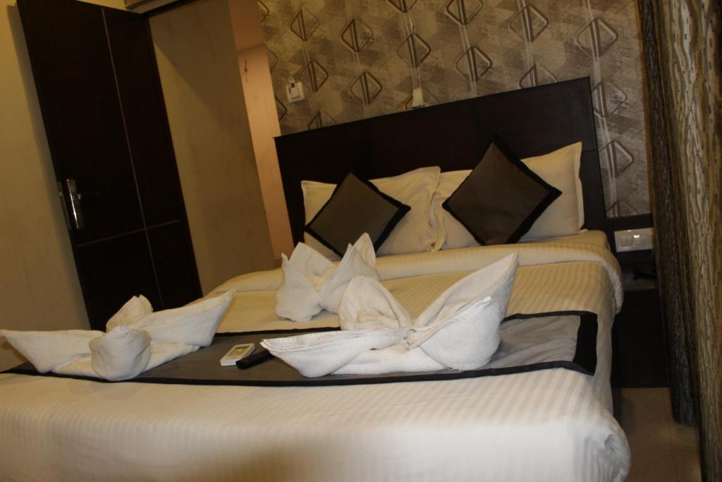 Postel nebo postele na pokoji v ubytování SKY GATE HOTEL Near Apollo MAIN, Women's & Children's US Consulate Sankara Netralaya Goethe Institute PrestigePalladium Shastri Bhavan Senmozhi Poonga Raj Ratnam Stadium TAJ Coromandal India Oil Bhavan Dr Mohan's Diabetics VAC Chennai