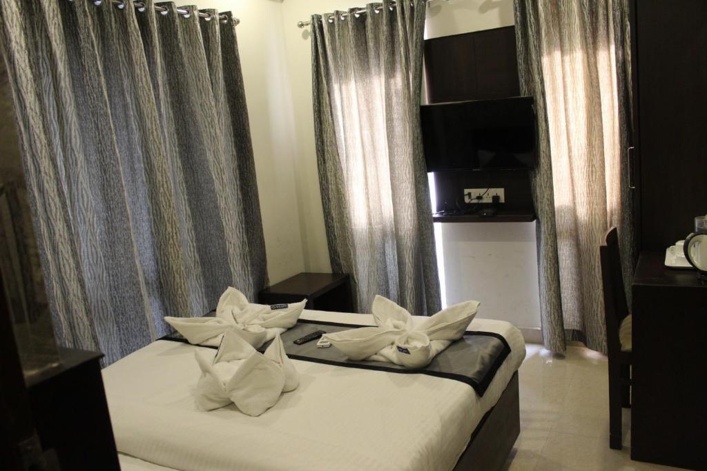 Postel nebo postele na pokoji v ubytování SKY GATE HOTEL Near Apollo MAIN, Women's & Children's US Consulate Sankara Netralaya Goethe Institute PrestigePalladium Shastri Bhavan Senmozhi Poonga Raj Ratnam Stadium TAJ Coromandal India Oil Bhavan Dr Mohan's Diabetics VAC Chennai