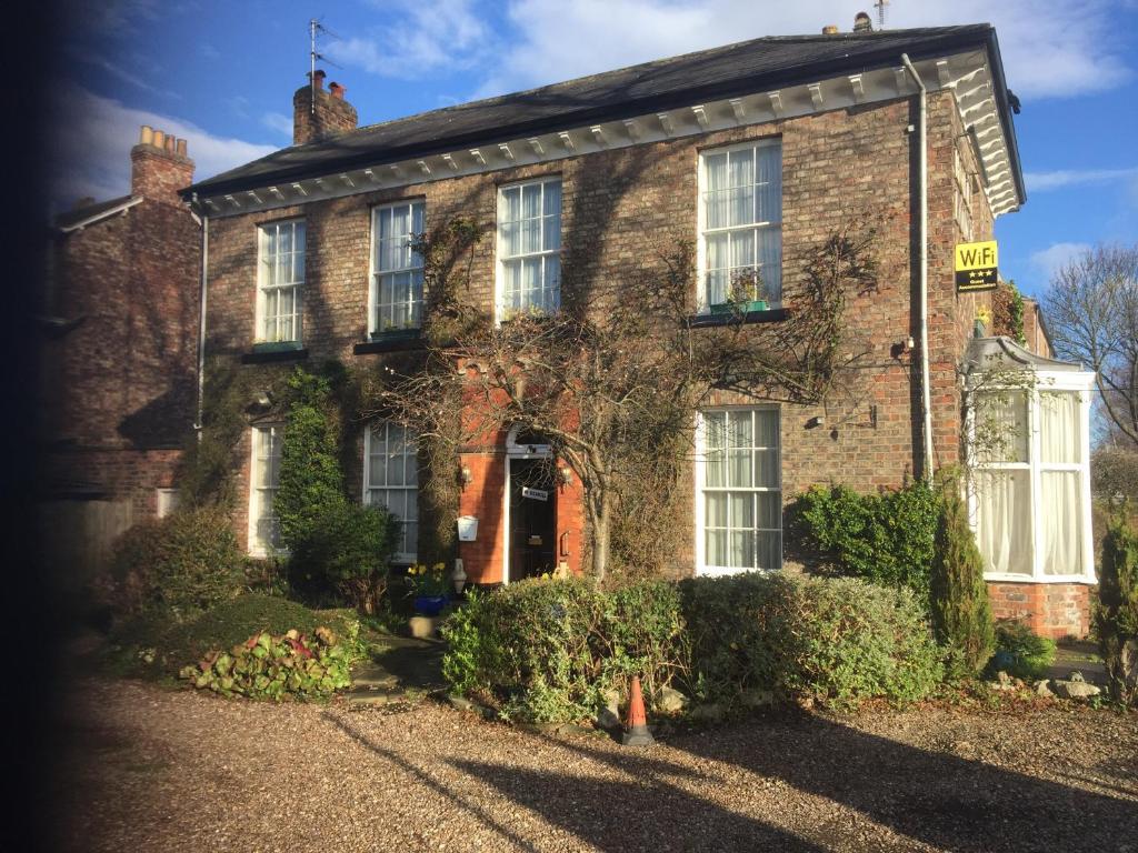 an old brick house with the front door open at Holly Lodge in York