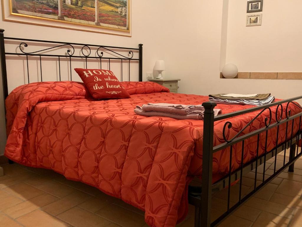 アッシジにあるIl Sementoneのベッド(赤い掛け布団、枕付)