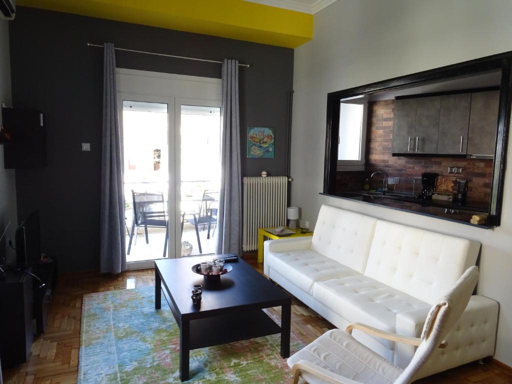 ein Wohnzimmer mit einem weißen Sofa und einem Tisch in der Unterkunft DP ZOGRAFOU APPARTMENT in Athen