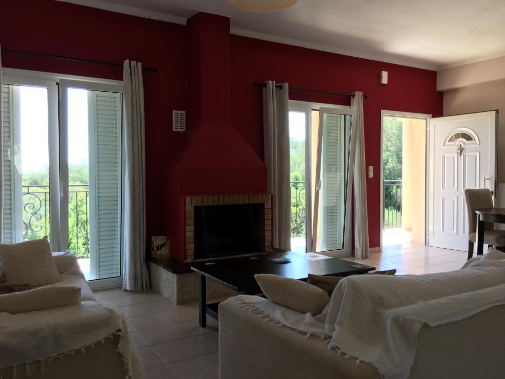 een woonkamer met rode muren en een open haard bij Villa Sunrise apartment in Gouvia