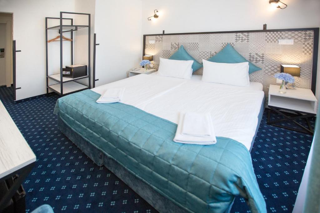 a bedroom with a large white bed with a blue blanket at Apart-Hotel Naumov in Moscow