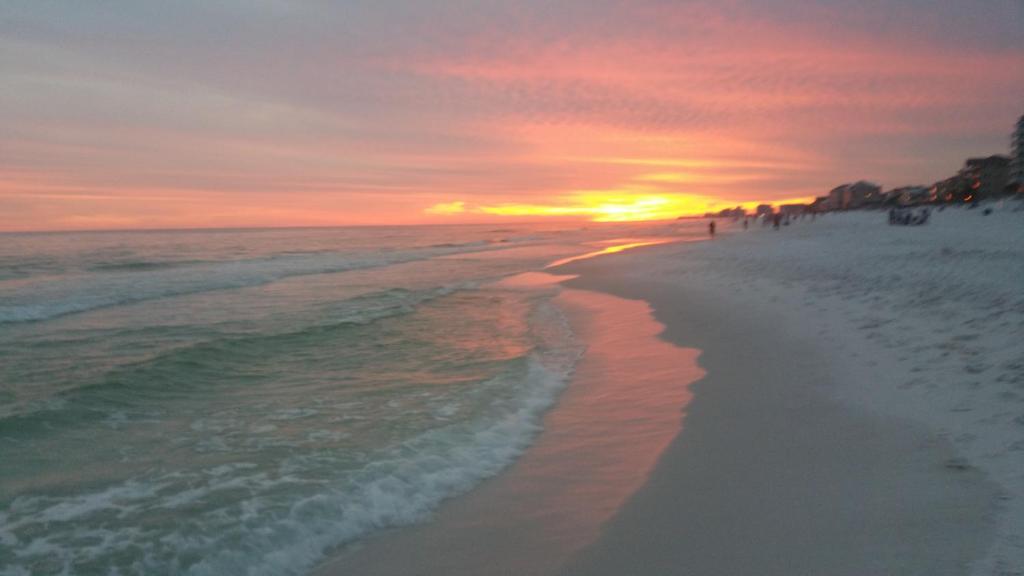a sunset on the beach with the sun setting at Destin Daydream in Destin