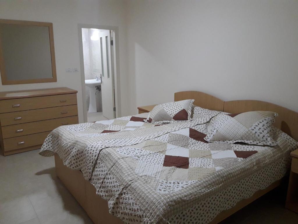 1 dormitorio con cama, tocador y espejo en Cypress Tree Apartments, en Bethlehem