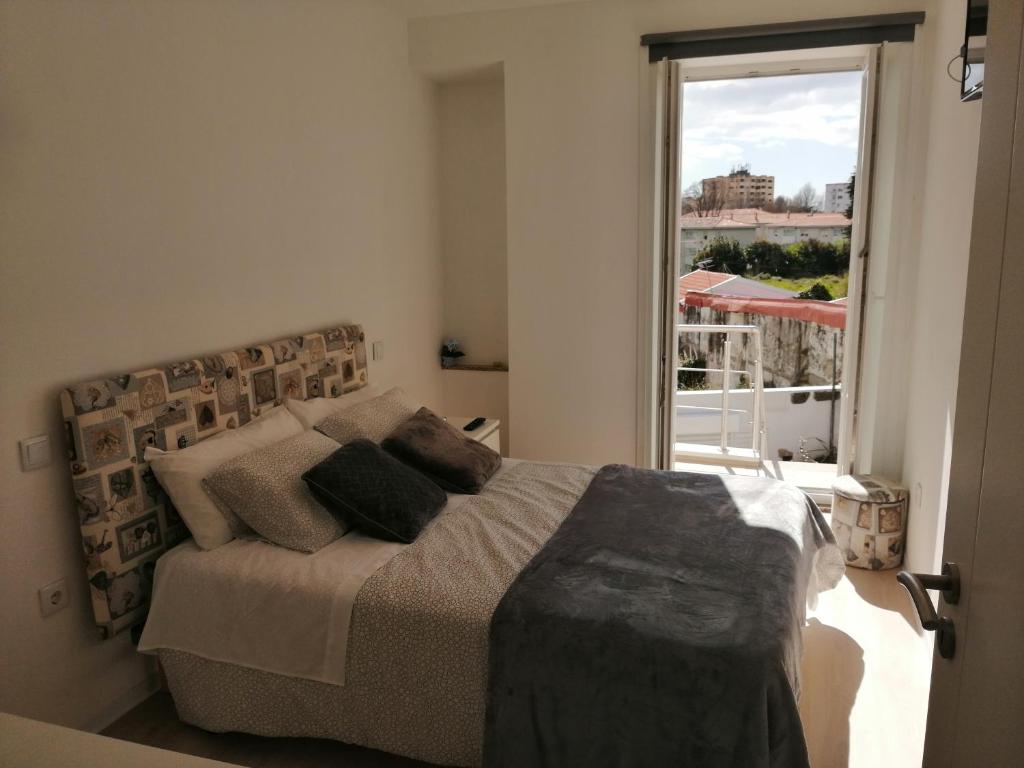 1 dormitorio con cama y ventana grande en Casa Ventuzelo, en Oporto