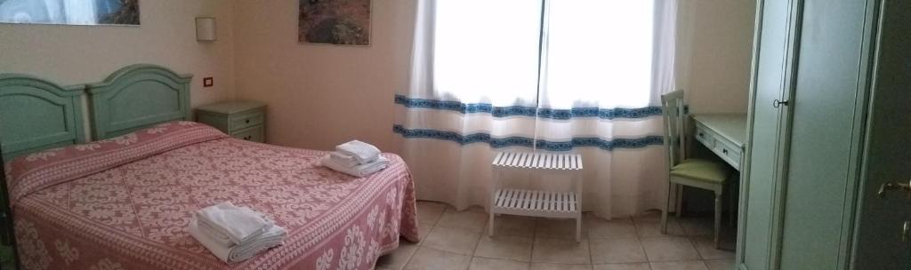 a small bedroom with two beds and a window at Agriturismo Archelao in Oristano