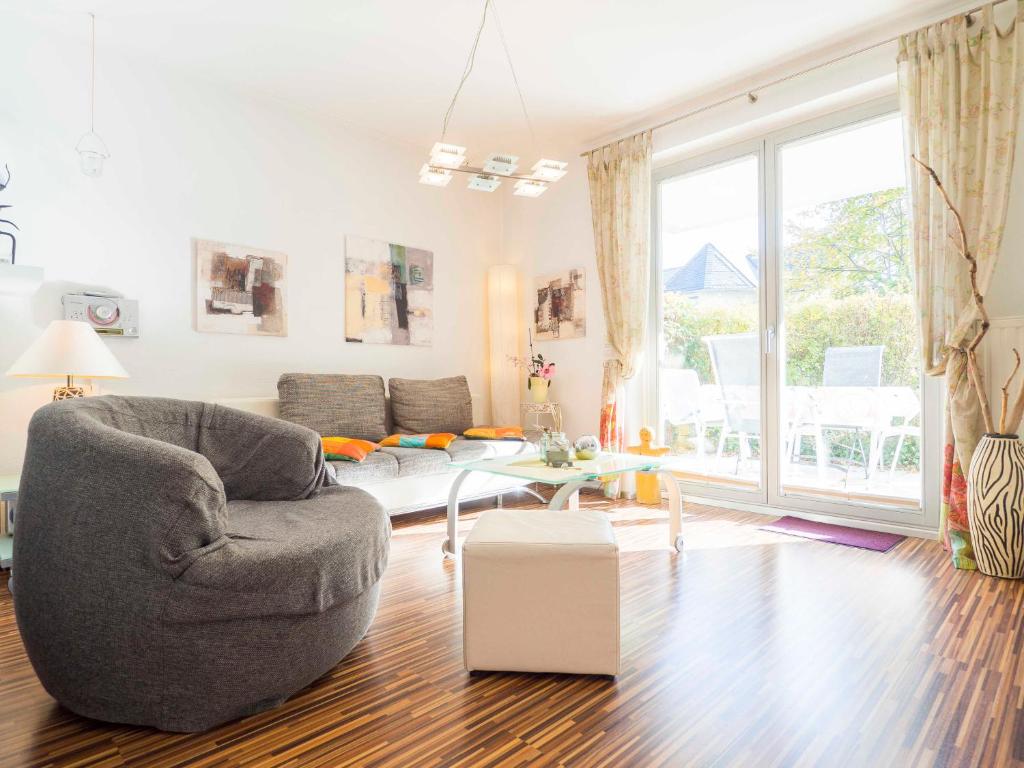 een woonkamer met een stoel en een bank bij Appartement No. 1 im Sonnenbad in Sassnitz