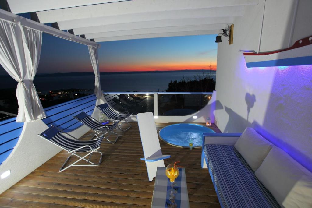 a balcony with a couch and chairs and a hot tub at Apartments Rustica in Makarska