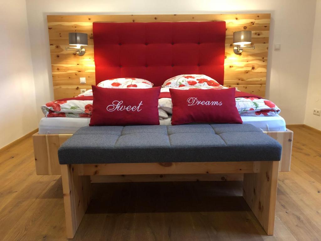 Una cama con dos almohadas rojas encima. en Vine & Design, en Langenlois