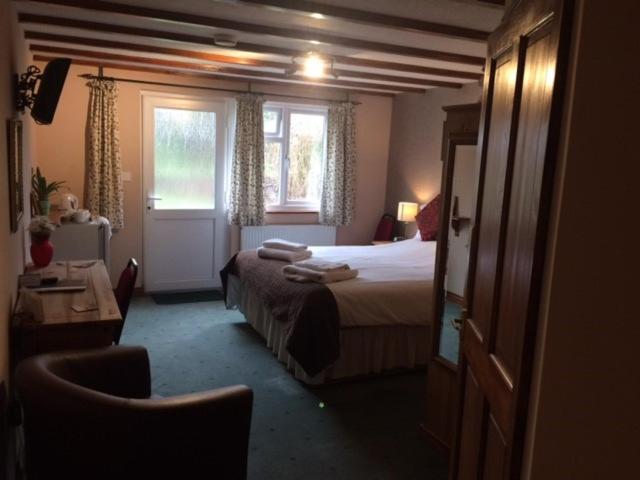 a hotel room with a bed and a window at Crown House & Lodges B&B in Helston