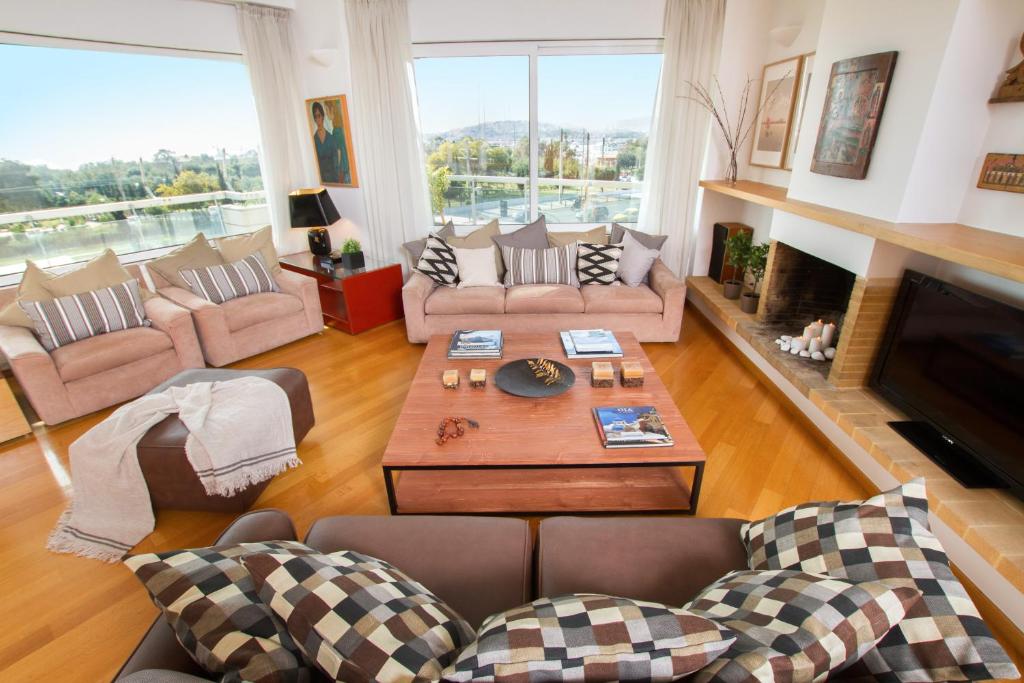 a living room with couches and a table and a fireplace at Athens luxurious apartment - sea view! in Athens