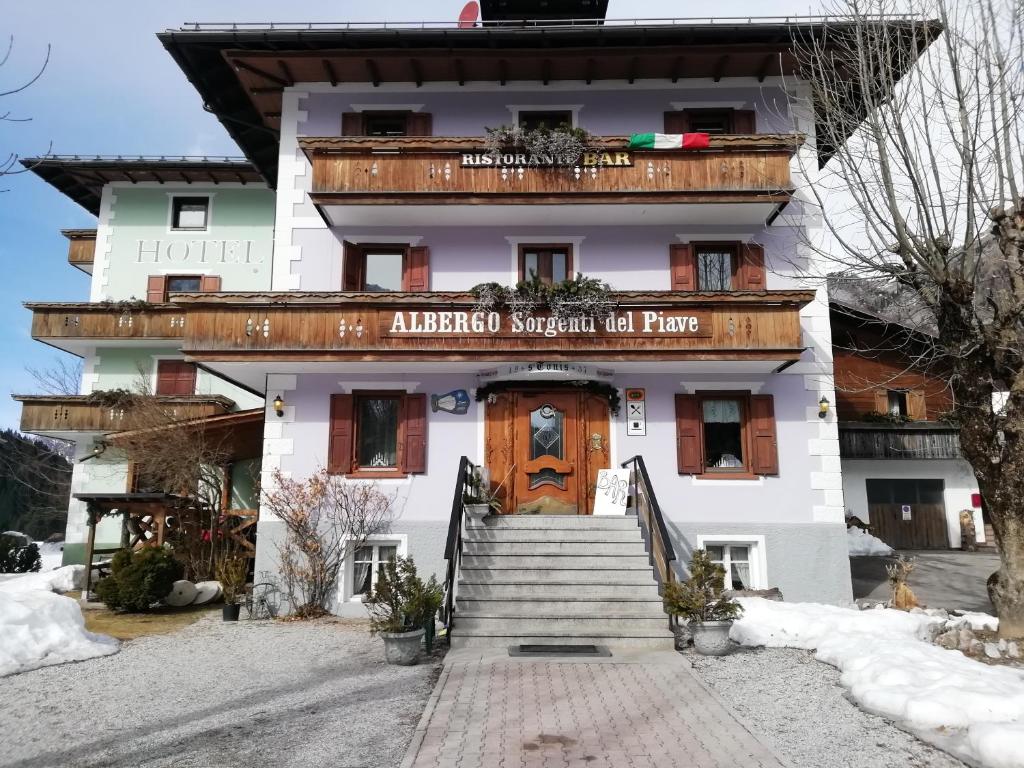 un edificio con un cartello che dice albuquerque avvicinarsi a tutto il parco di ALBERGO SORGENTI DEL PIAVE a Sappada