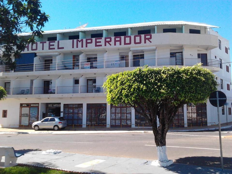 a white building with a tree in front of it at Hotel Imperador in Caldas Novas