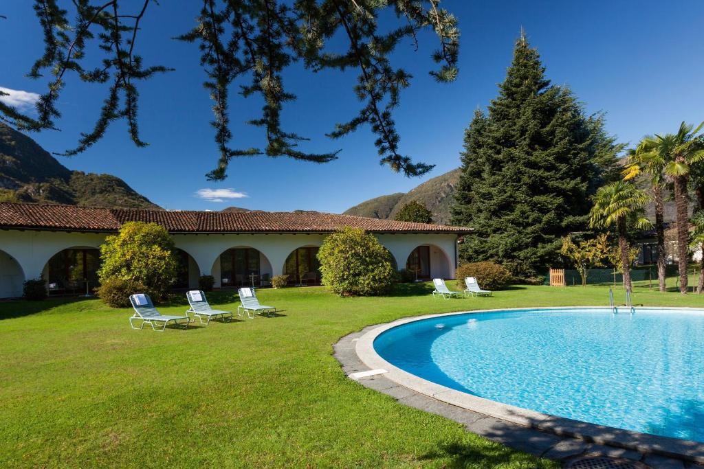 une cour avec une piscine et une maison dans l'établissement Garni Elena, à Losone