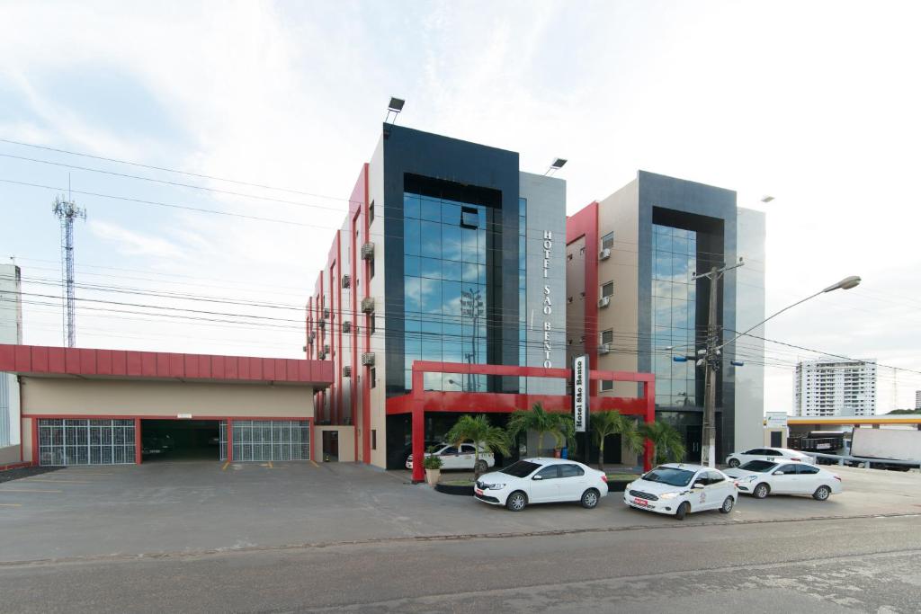 un grupo de coches estacionados frente a un edificio en Hotel São Bento, en Marabá