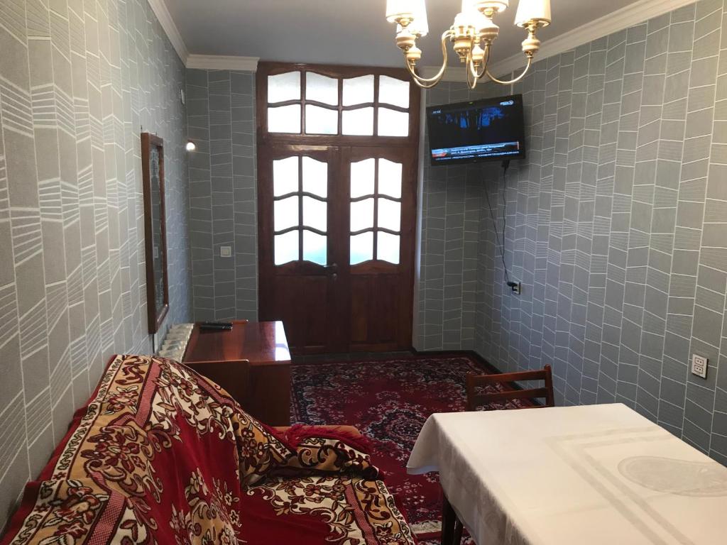 um quarto com uma cama, uma janela e uma televisão em Hope Lake city Apartment em Zaqatala