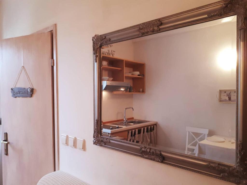 espejo en la pared de un baño con lavabo en House Kate, en Rovinj