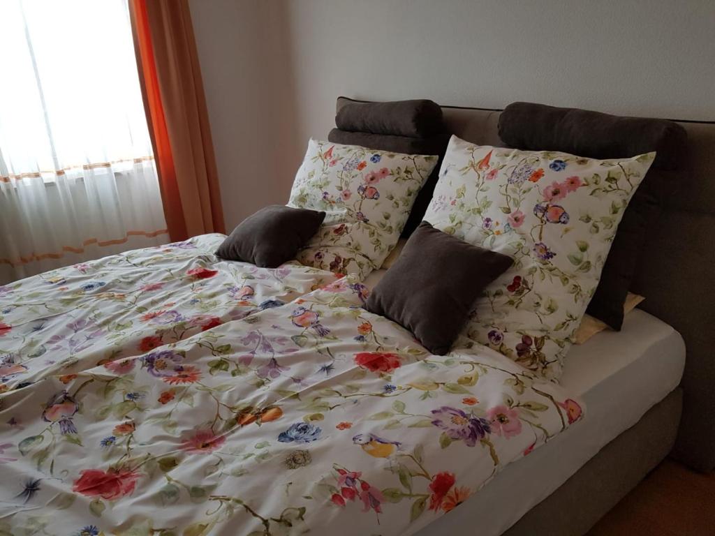 een bed met een bloemendeken en kussens erop bij Ferienwohnung Zentrumsnah in Esslingen