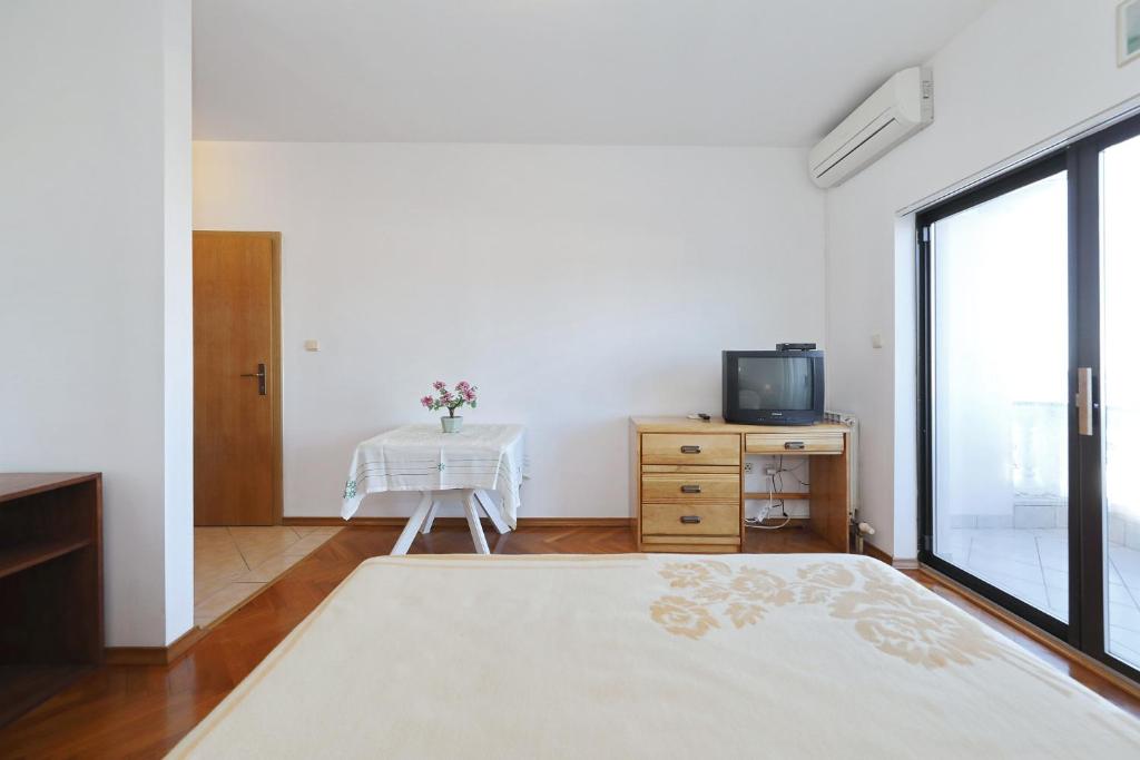 a white room with a table and a tv at Villa Vukic in Vrsi