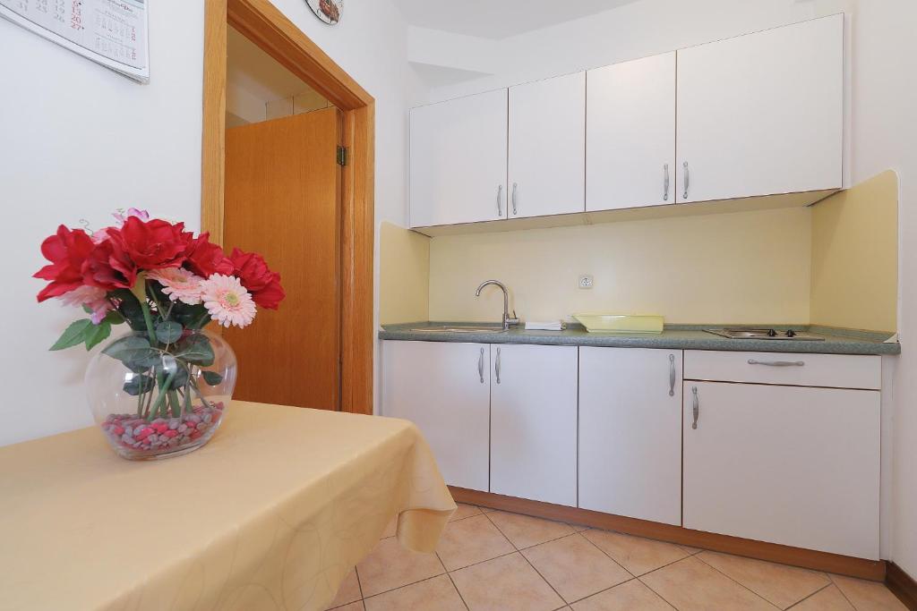 a kitchen with a vase of flowers on a table at Villa Vukic in Vrsi