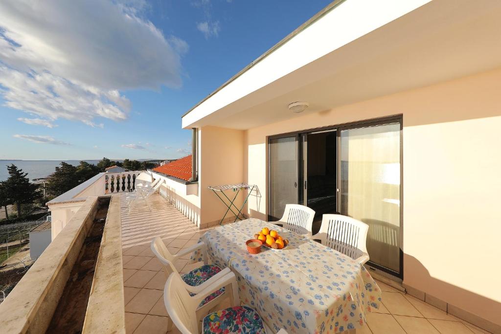 a balcony with a table and chairs and a view of the ocean at Villa Vukic in Vrsi