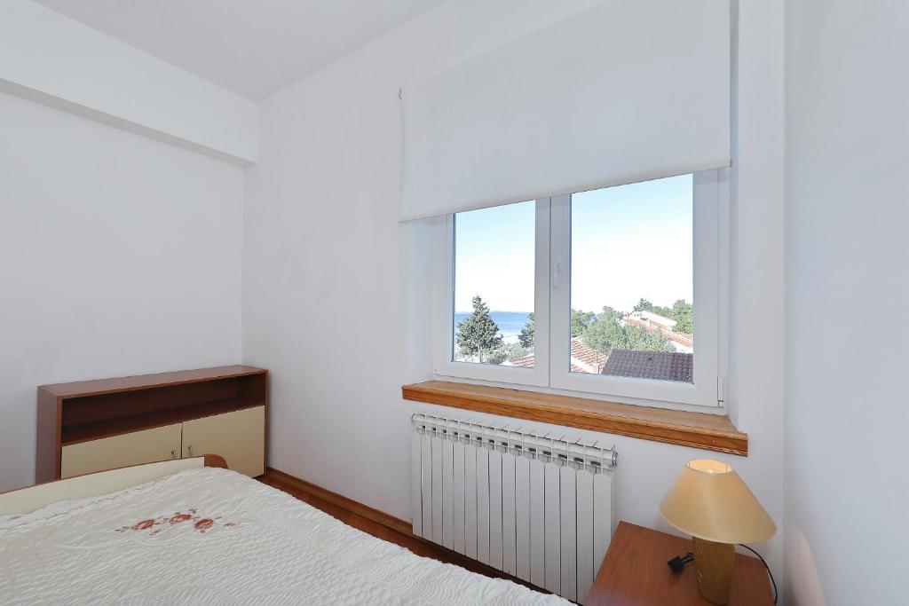 a bedroom with a bed and a window at Villa Vukic in Vrsi
