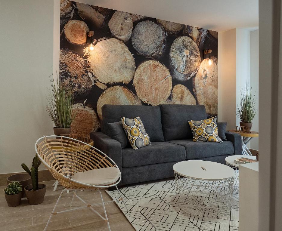 a living room with a blue couch and a wall of logs at Homely Salamanca in Salamanca