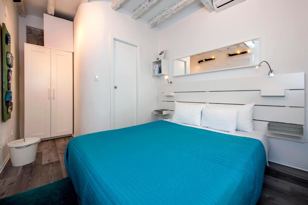 una camera con letto blu e pareti bianche di Room Marinata a Rovigno (Rovinj)