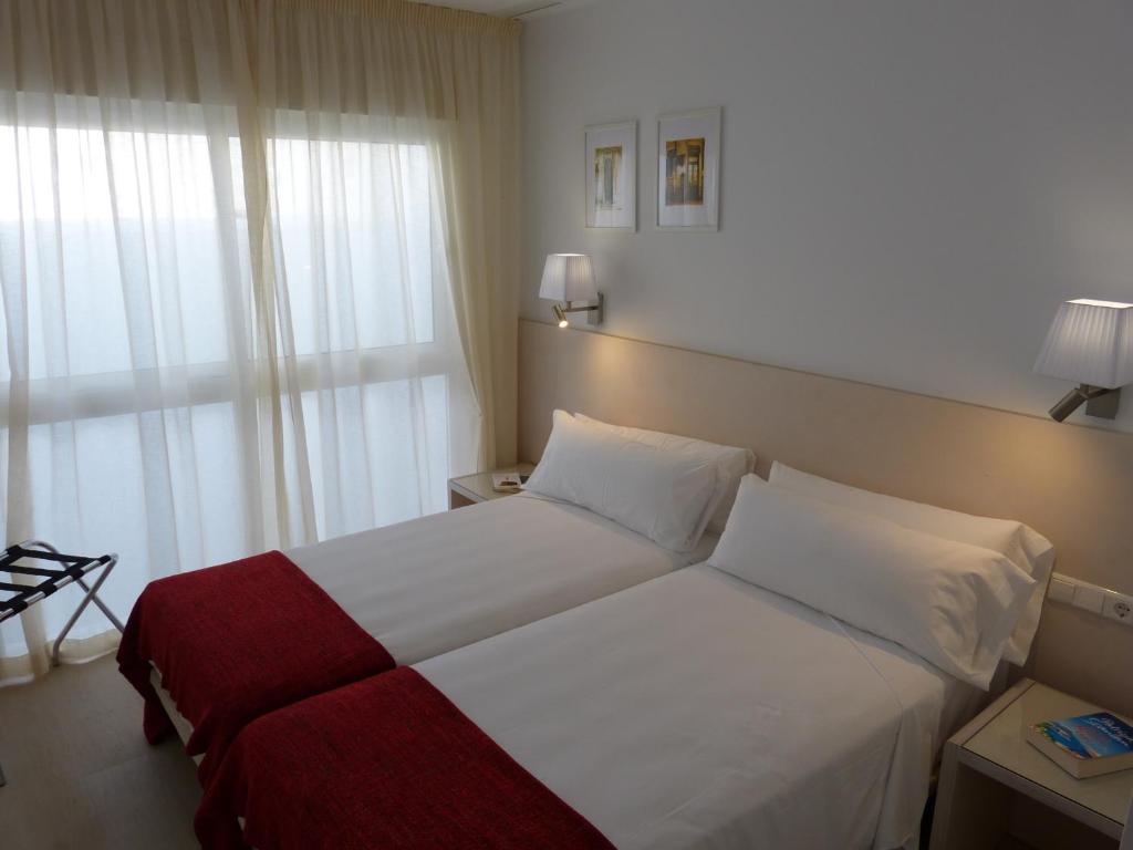 a hotel room with a bed and a window at Apartamentos Patagonia Sur in Cádiz