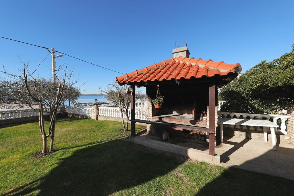 a small gazebo with a bench in a yard at Villa Vukic in Vrsi