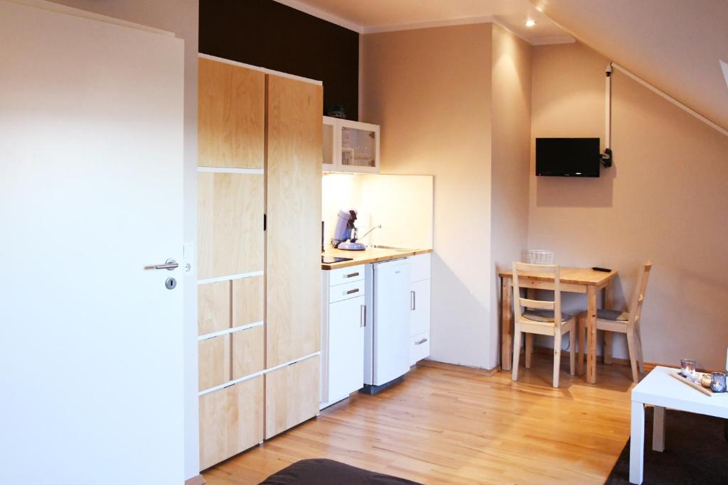 a small kitchen with a white refrigerator and a table at Modernes Studio in Richrath in Langenfeld