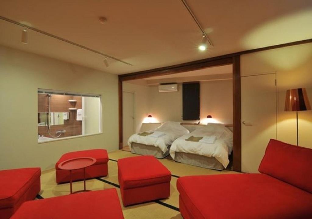 a bedroom with a bed and a couch and a mirror at Address Nozawa Suite / Vacation STAY 22748 in Nozawa Onsen