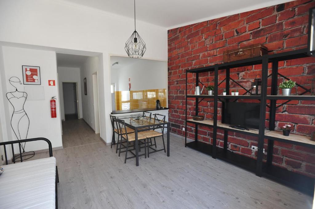 un soggiorno con parete in mattoni e tavolo con sedie di Lagos Central Apartments Ap 14 a Lagos
