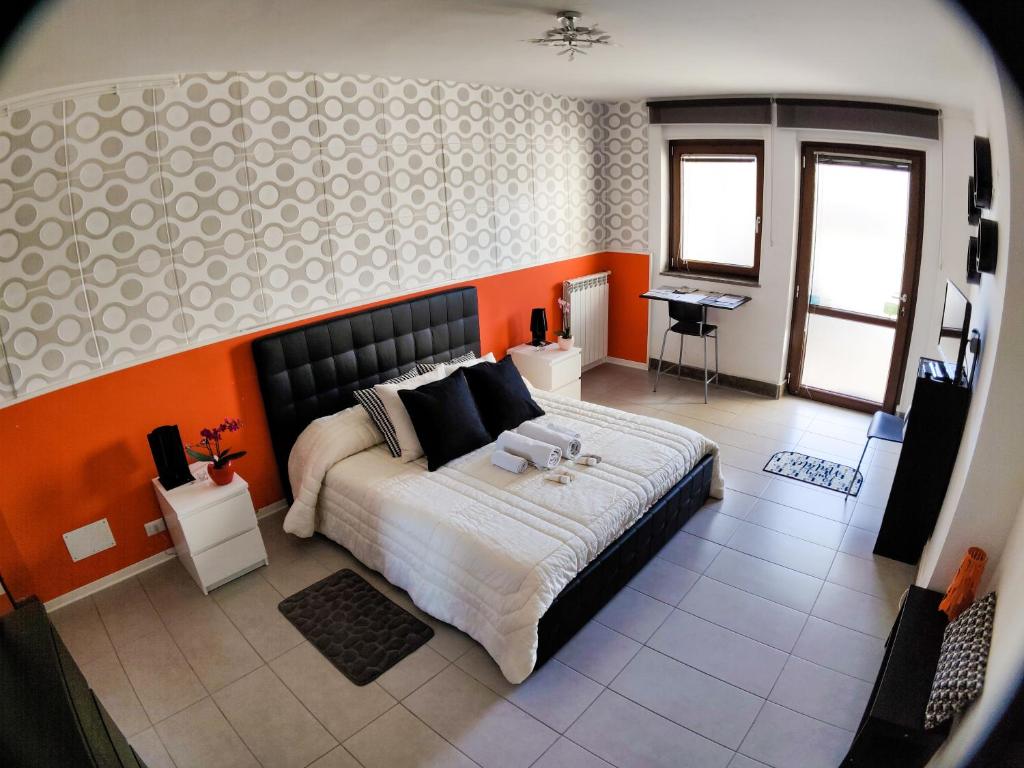 ヴィテルボにあるBed and Breakfast La Palanzanaのベッドルーム1室(オレンジ色の壁の大型ベッド1台付)