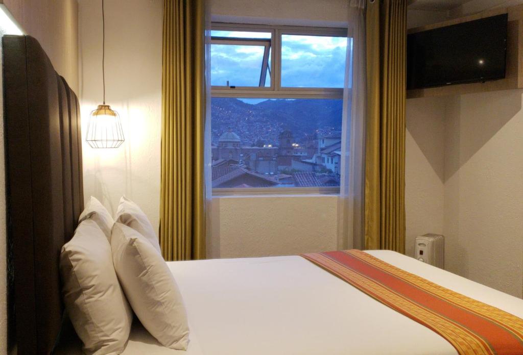 ein Hotelzimmer mit einem Bett und einem Fenster in der Unterkunft Hotel Sueños del Inka in Cusco