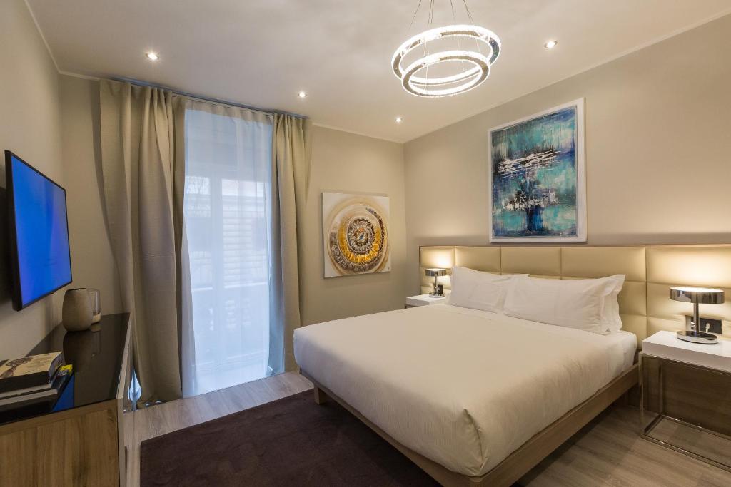 una camera da letto con un grande letto bianco e una finestra di Clementi Portrait a Roma