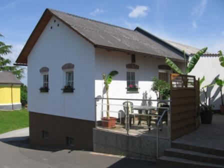 a small white house with a table in front of it at S´ Kellerstoeckl in Fehring