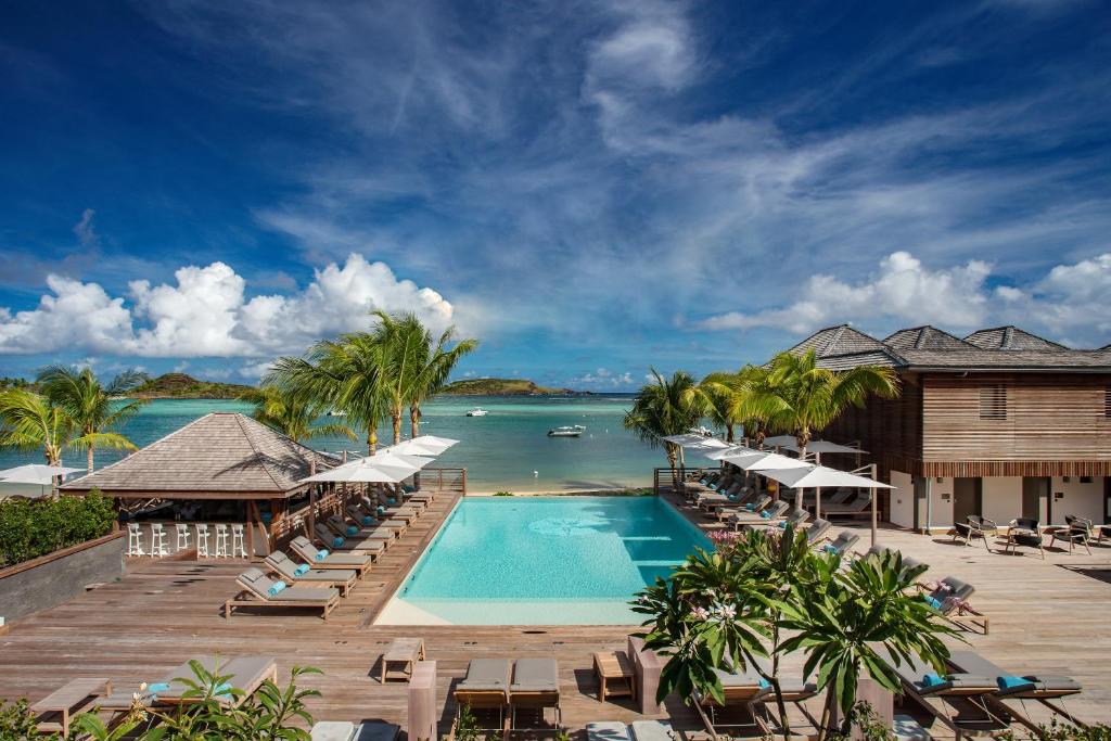 a resort with a swimming pool and a view of the ocean at Le Barthélemy Hotel & Spa in Gustavia