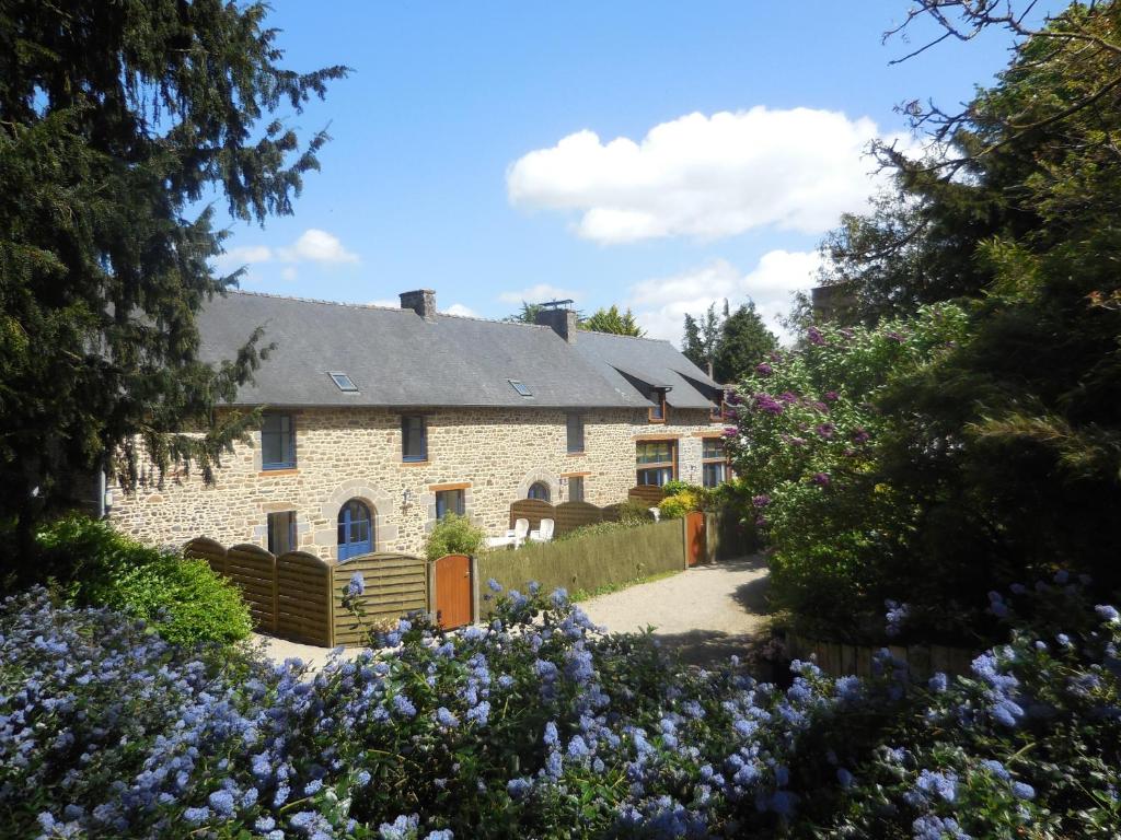 a stone house with flowers in front of it at Try-Logis in Plerguer