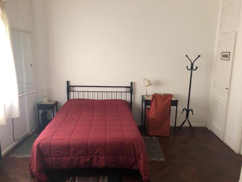 een slaapkamer met een bed met een rode deken bij San Telmo Easy in Buenos Aires