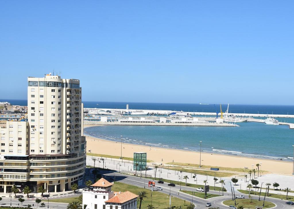 vista su una spiaggia con un edificio e sull'oceano di Wellness Home a Tangeri