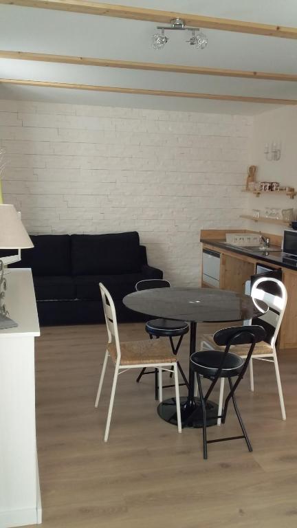 a living room with a table and chairs and a couch at Joli studio sympa in Saint-Jean-Saint-Nicolas